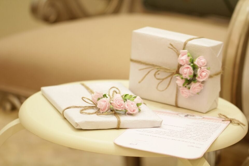 two wrapped presents with flowers on a table
